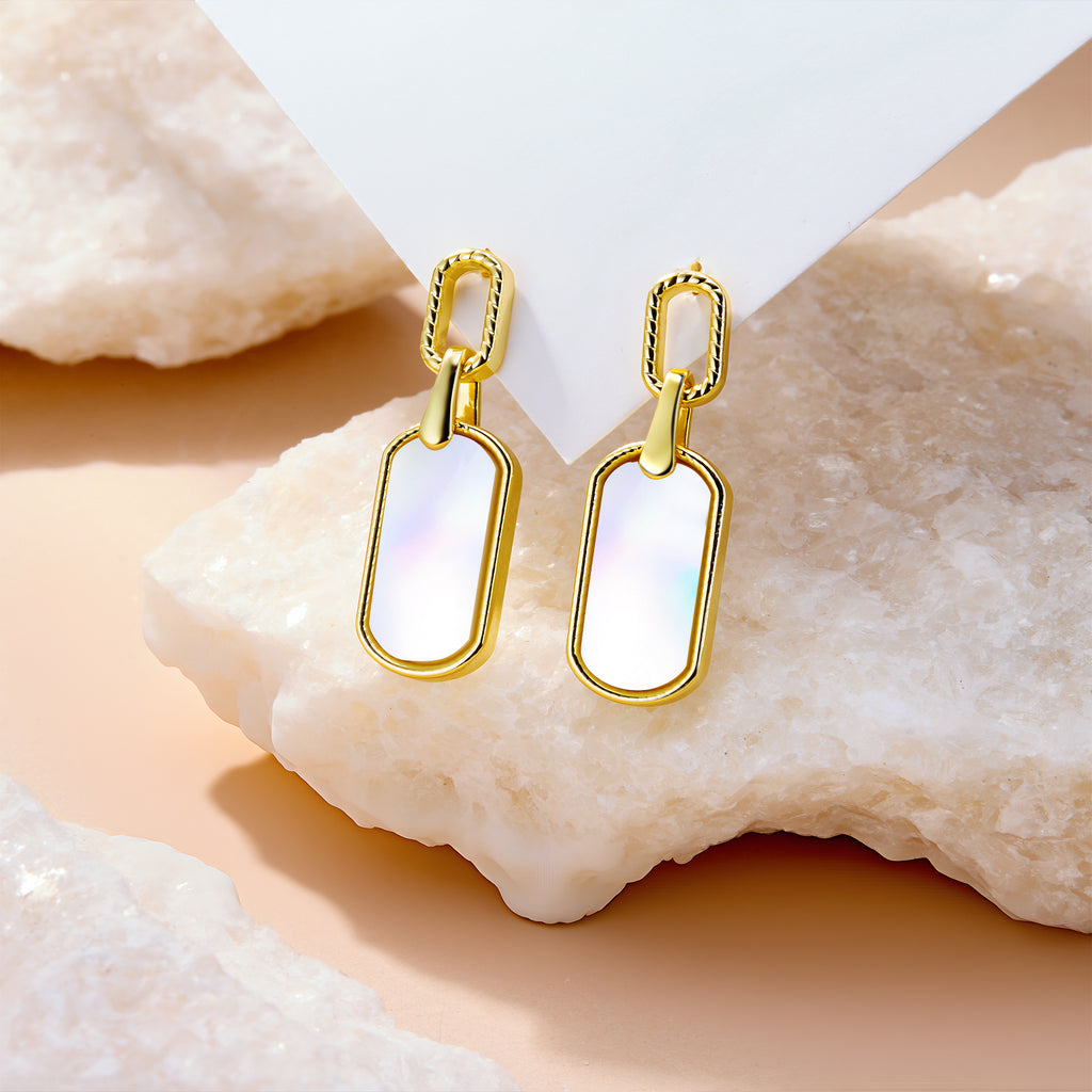 Pearl shell style statement earrings, gold-tone frames with iridescent white rectangular dangles.