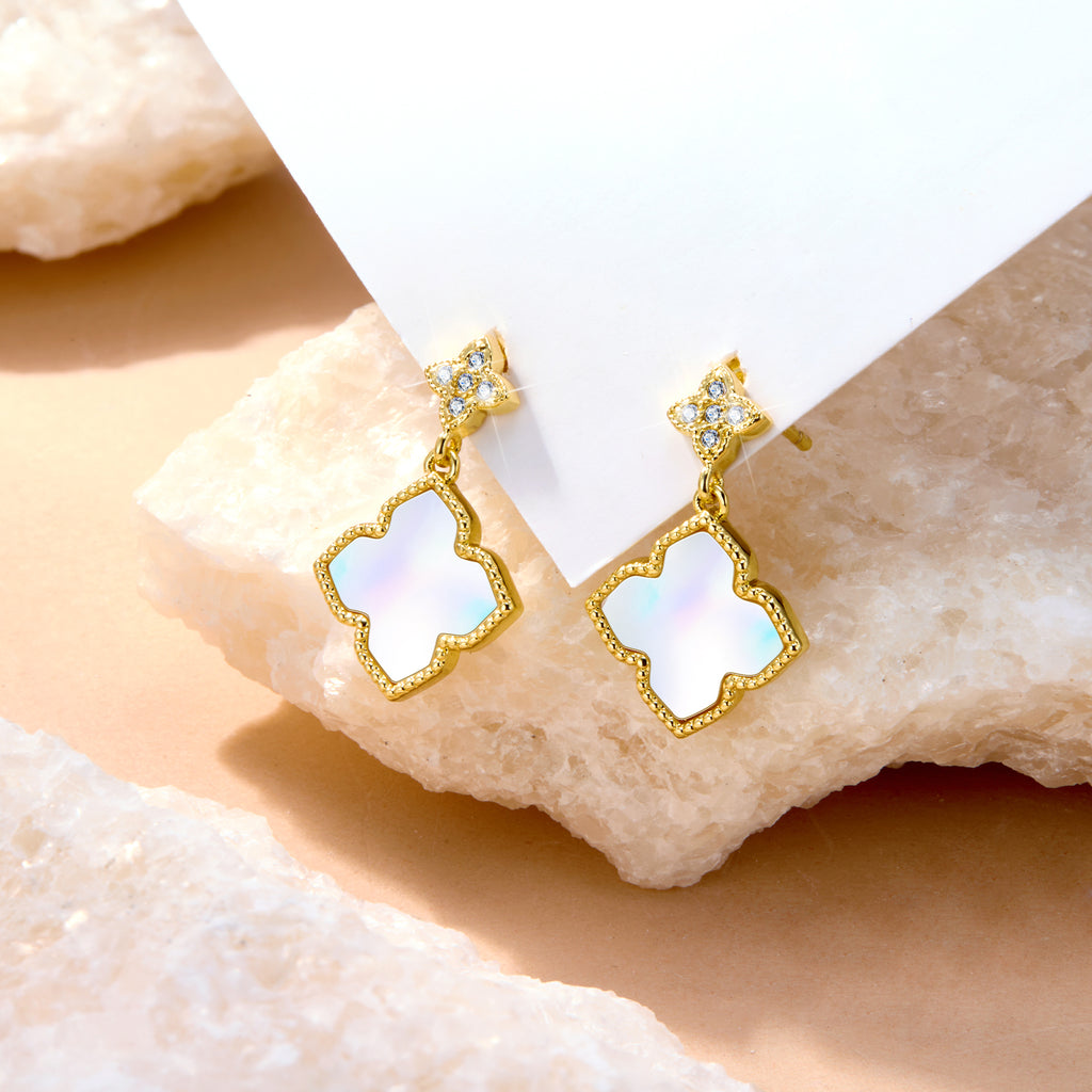 Four-leaf clover charm stud earrings with gold-tone clover and blue crystal accents