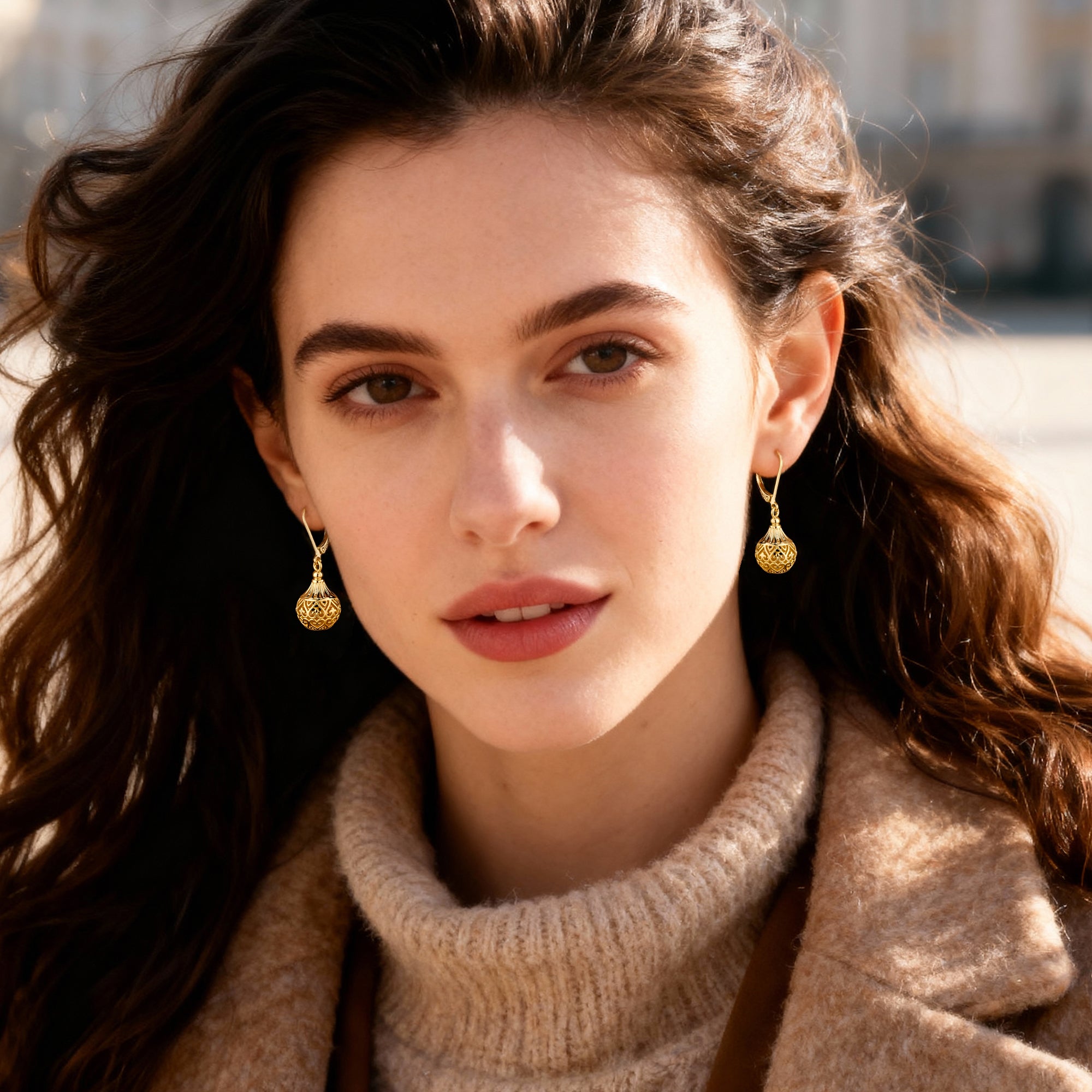 Gold hollow lantern drop earrings on model, ornate filigree globe with bead detail
