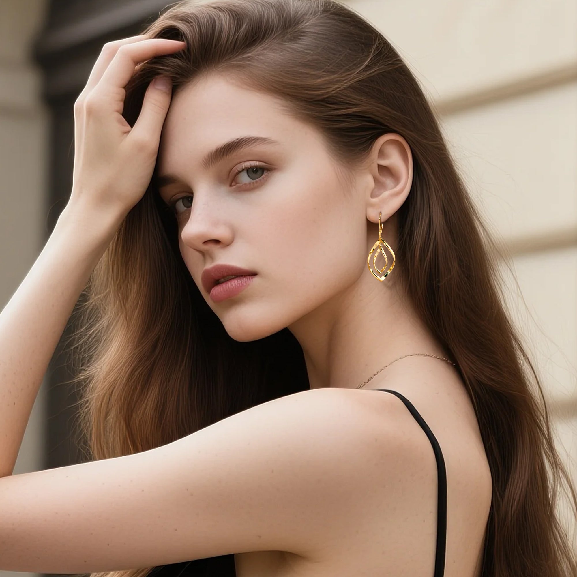 Gold drop earrings featuring a double-twist teardrop loop design