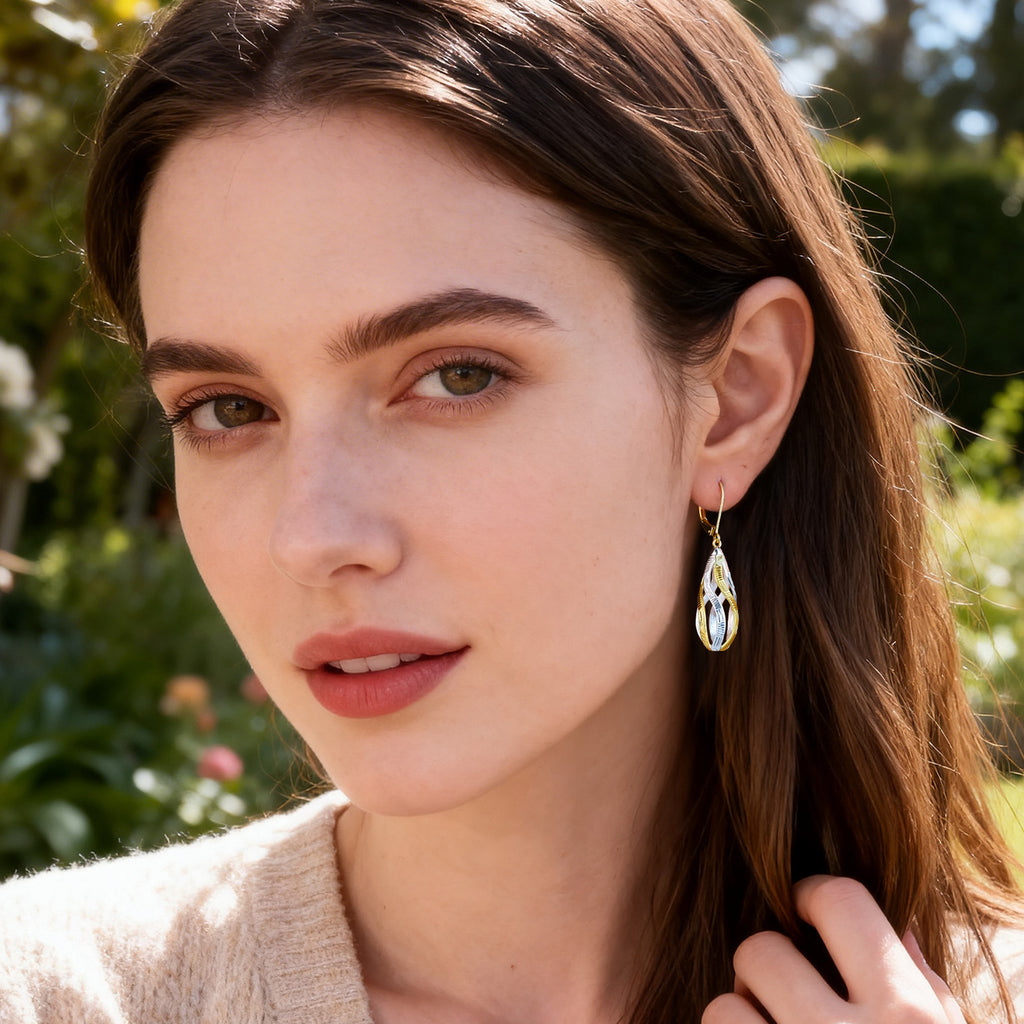Gold-and-silver twisted teardrop dangle earrings with ridged two-tone finish