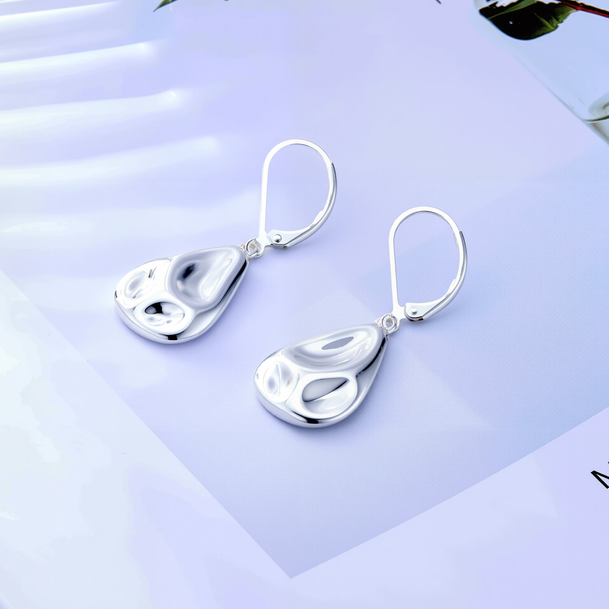 Silver hammered teardrop earrings with lever backs, pair on display card.