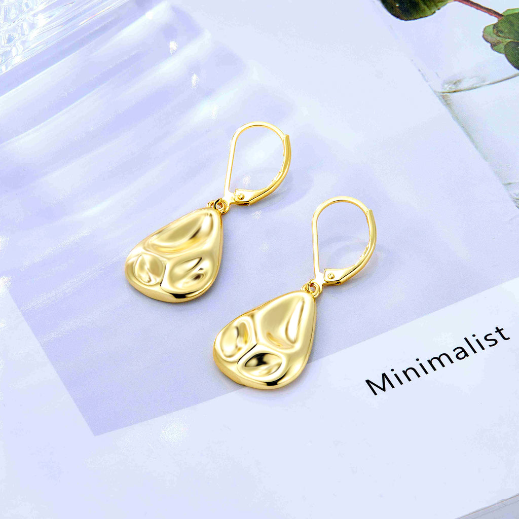 Gold teardrop earrings with hammered finish and lever hooks, pair on light card.