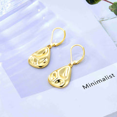 Gold teardrop earrings with hammered finish and lever hooks, pair on light card.
