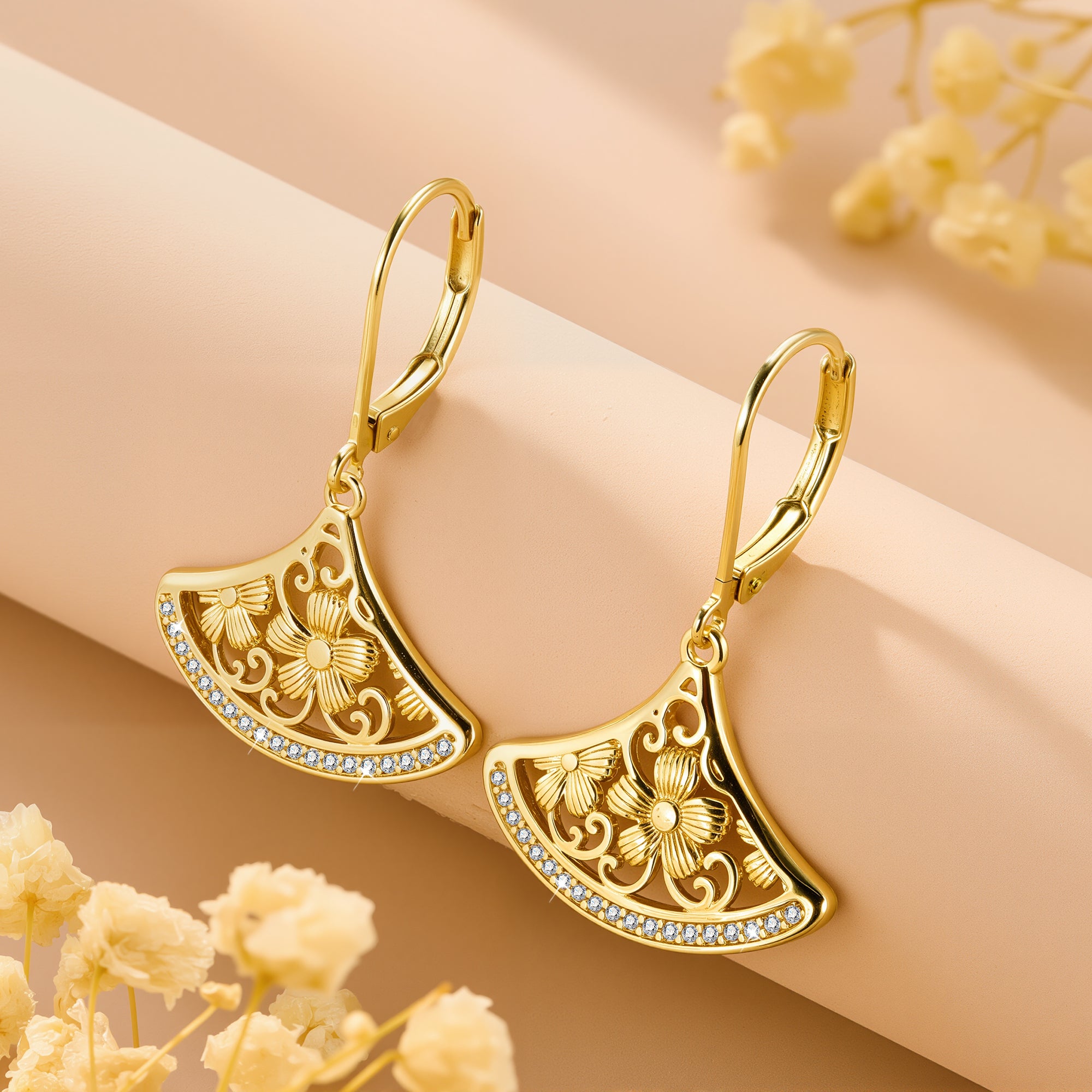 Gold-tone crescent fan drop earrings with rhinestone border and ornate floral cutouts