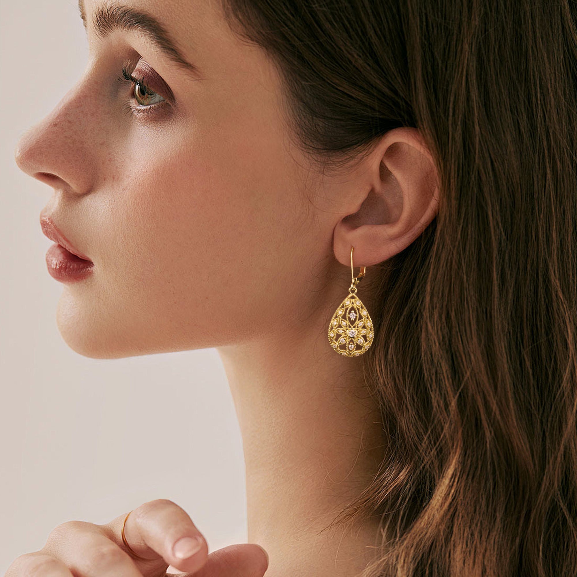 Gold Filigree CZ dangle earring on model, teardrop design with sparkling round stones.