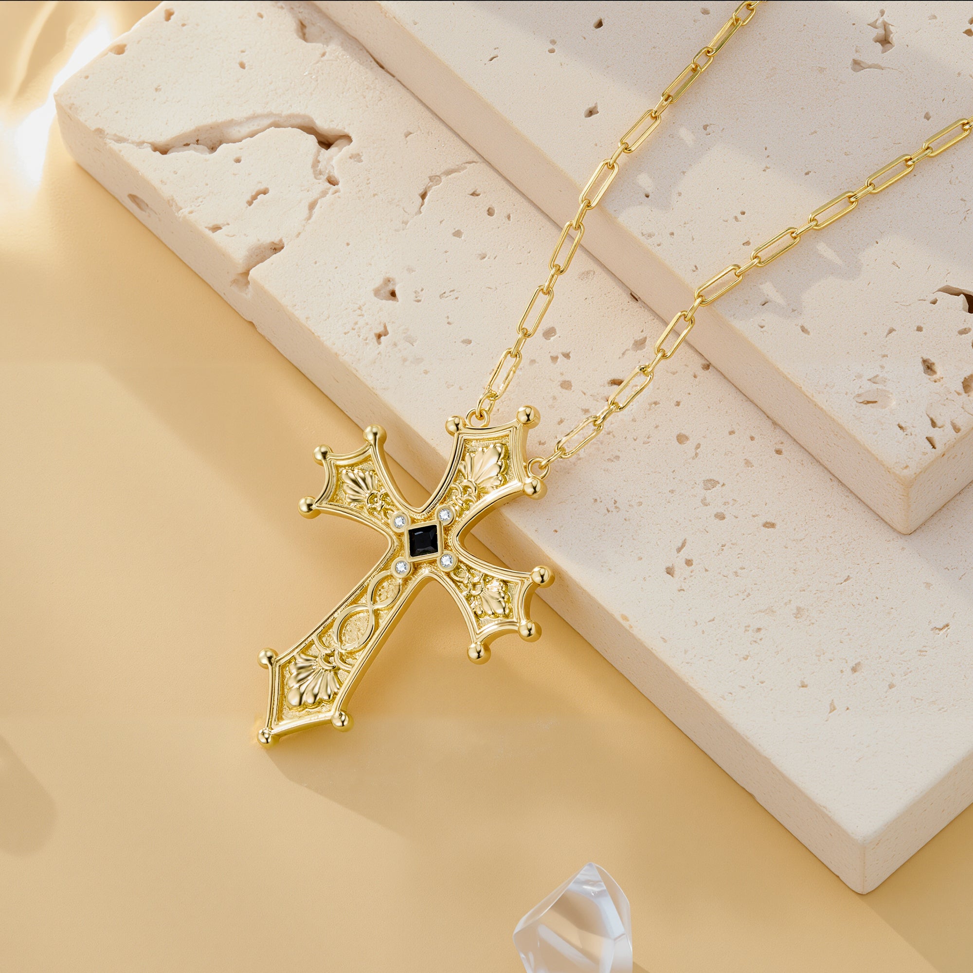 Ornate gold baroque cross pendant necklace on curb chain with dark center gem