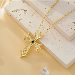 Ornate gold baroque cross pendant necklace on curb chain with dark center gem