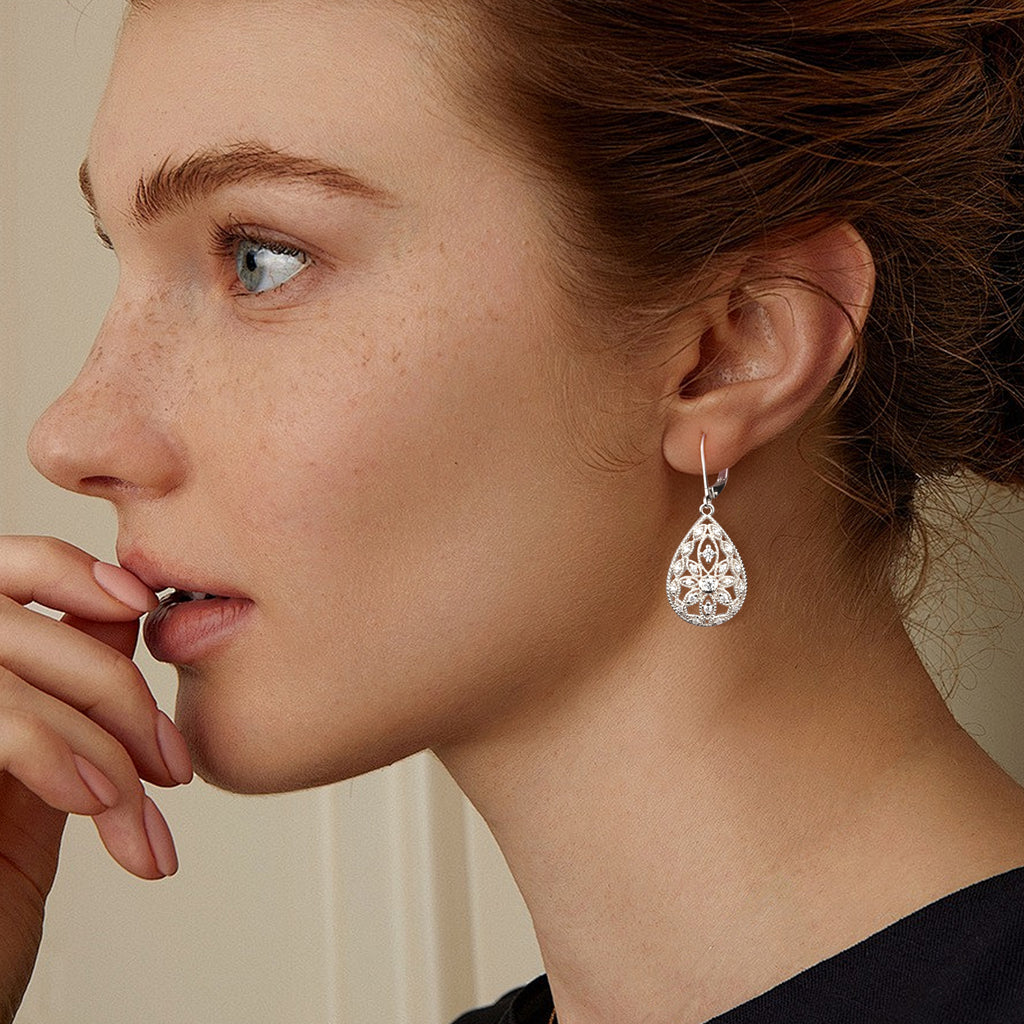 Silver Filigree CZ dangle earring on model, teardrop lattice with round stone details.