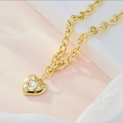 Heart pendant on a gold-toned link chain with rhinestone accents