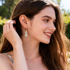 Twisted teardrop dangle earrings in gold and silver with ridged two-tone design
