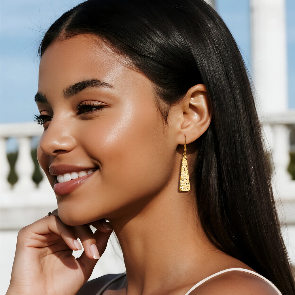 Hammered bar drop earrings, gold tone; model wearing dangling textured bars