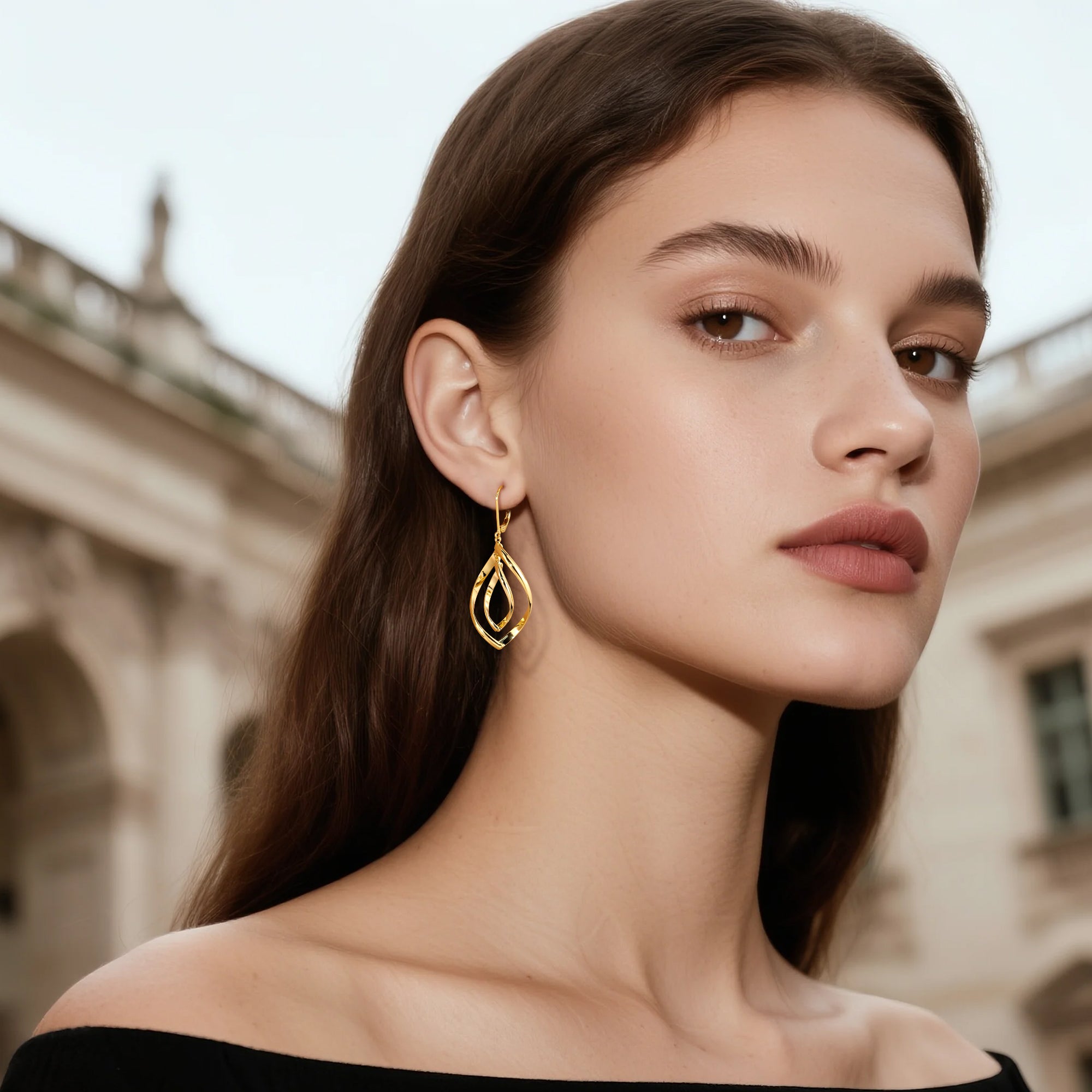 Gold teardrop double-twist drop earrings hanging from hook closures