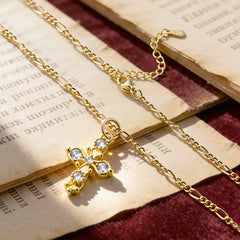 Gold cross pendant necklace with round stone accents and link chain