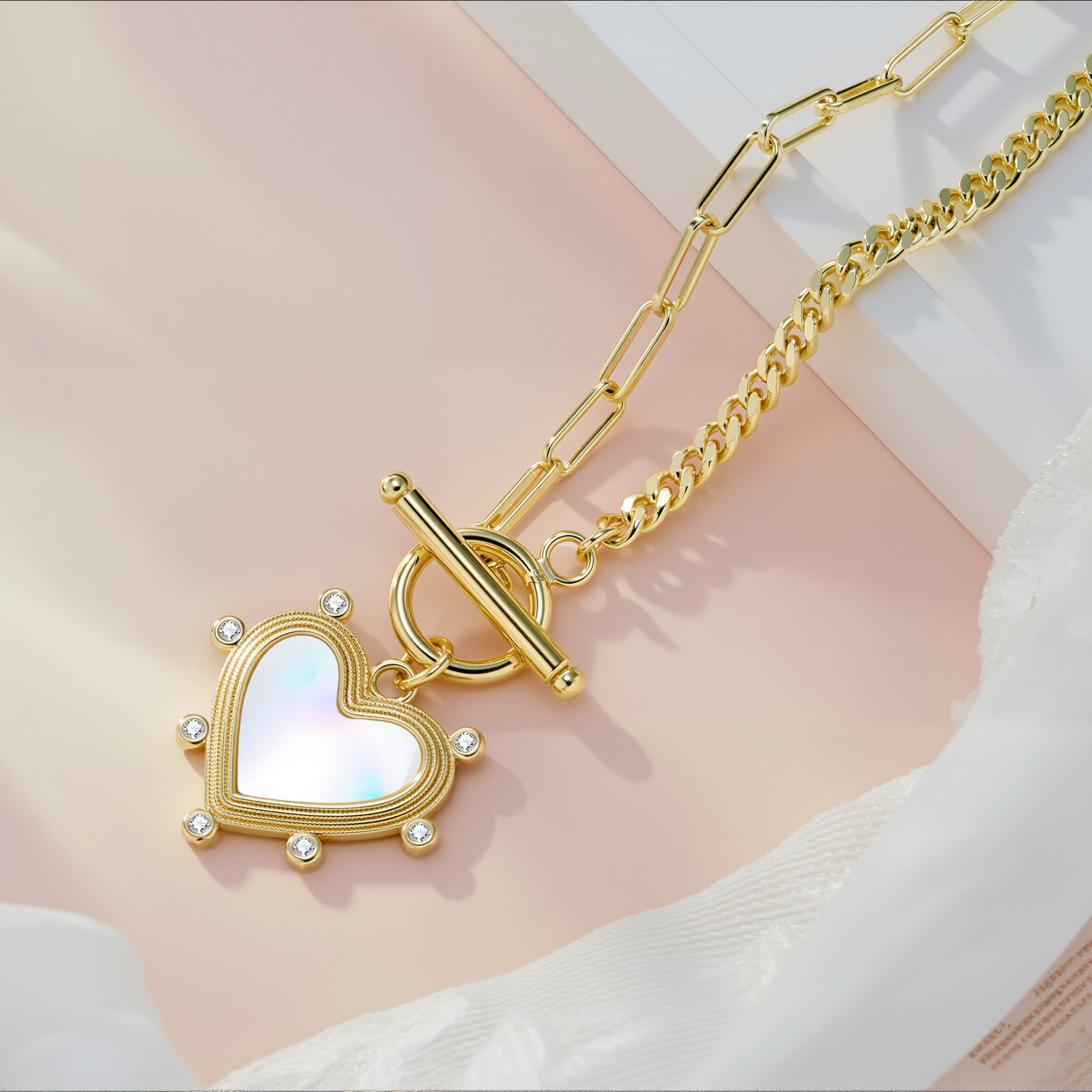 Gold heart pearl charm necklace with blue heart center and stone accents