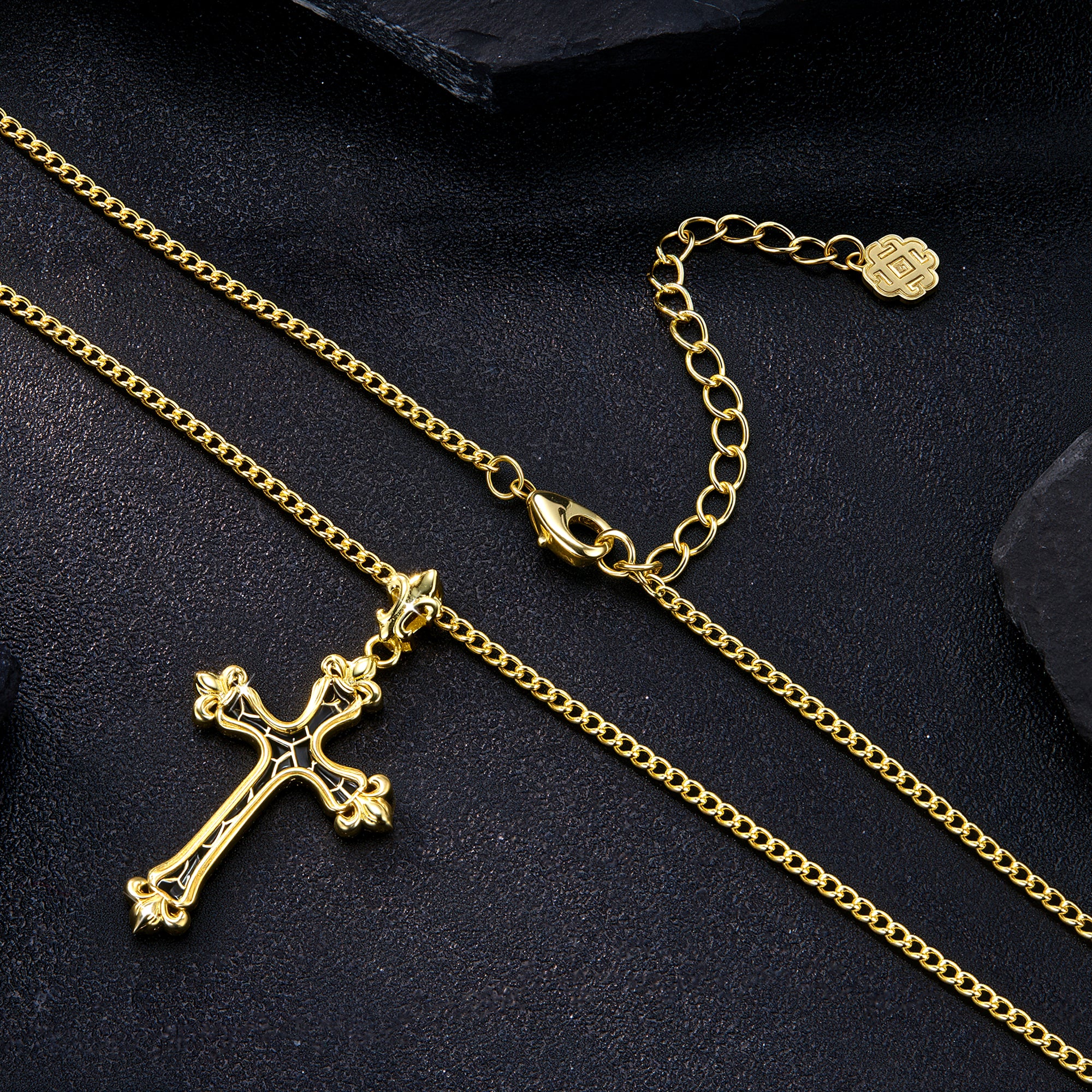 Gold cross necklace and clasp view; black-enamel cross pendant and knot charm