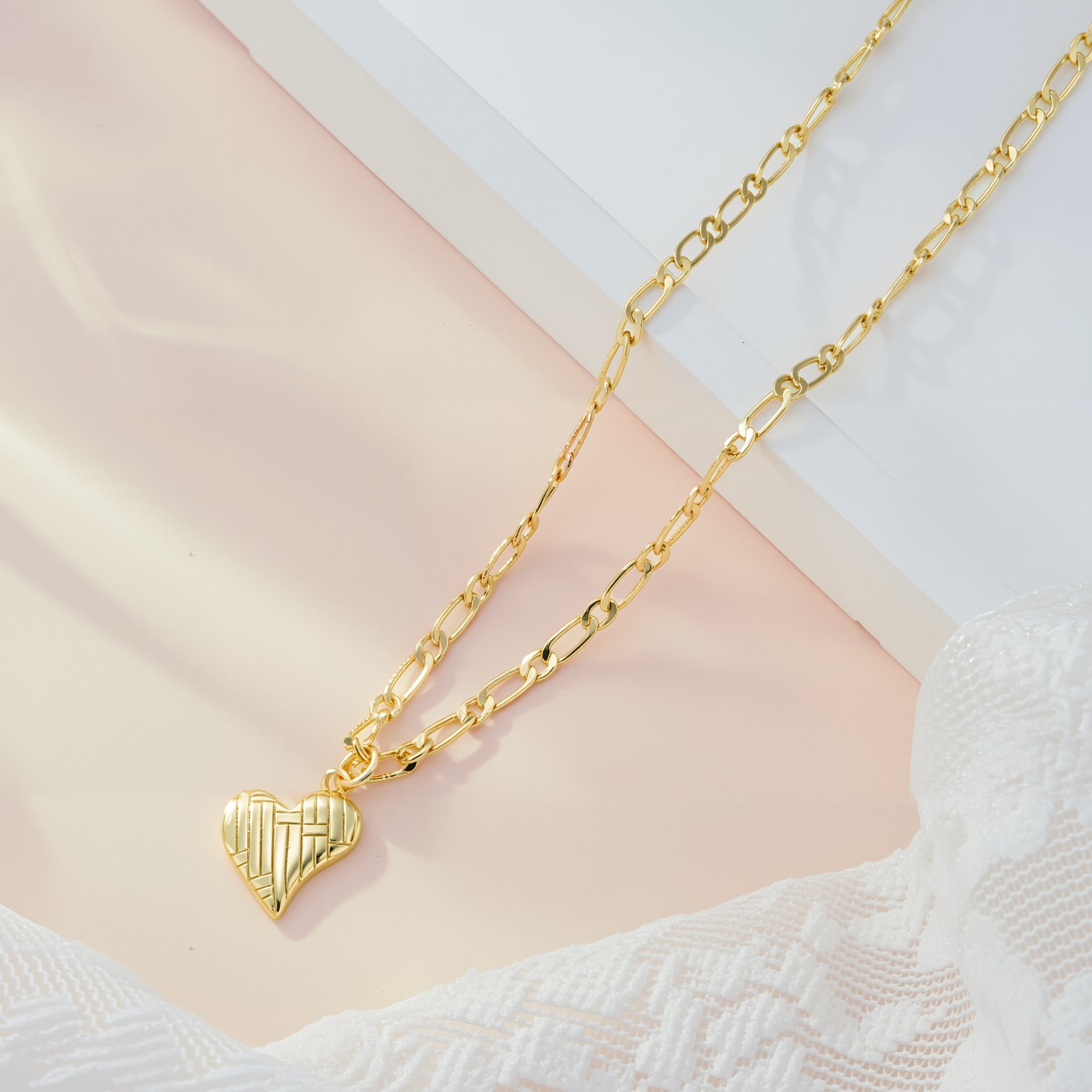 Gold Figaro chain necklace with textured ridged heart pendant