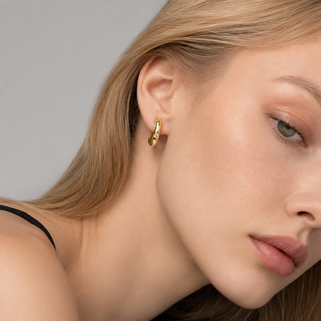 Woman wearing gold plated moissanite hoop earrings