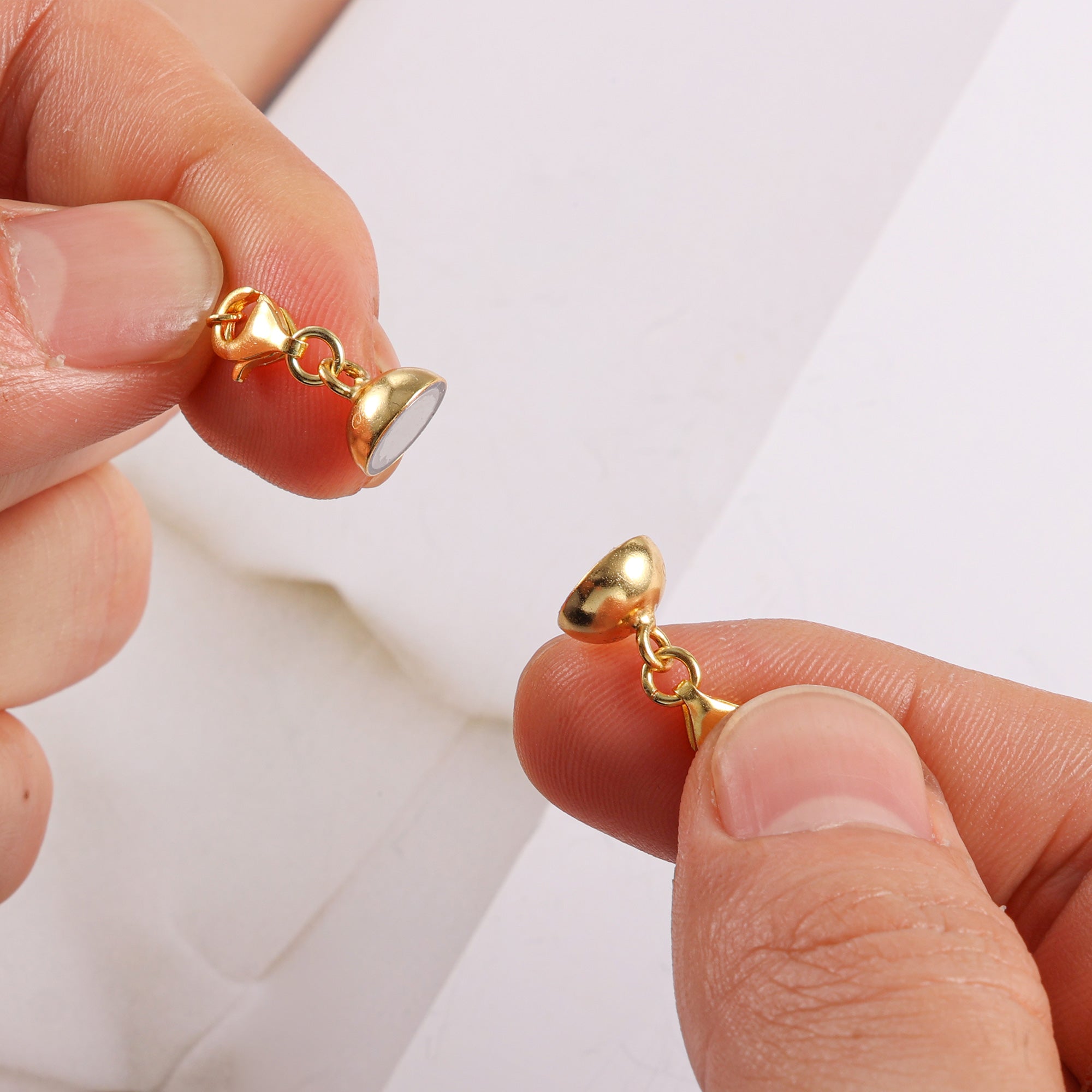 Gold-tone extender clasp with small bell-shaped connector and linked chain loops