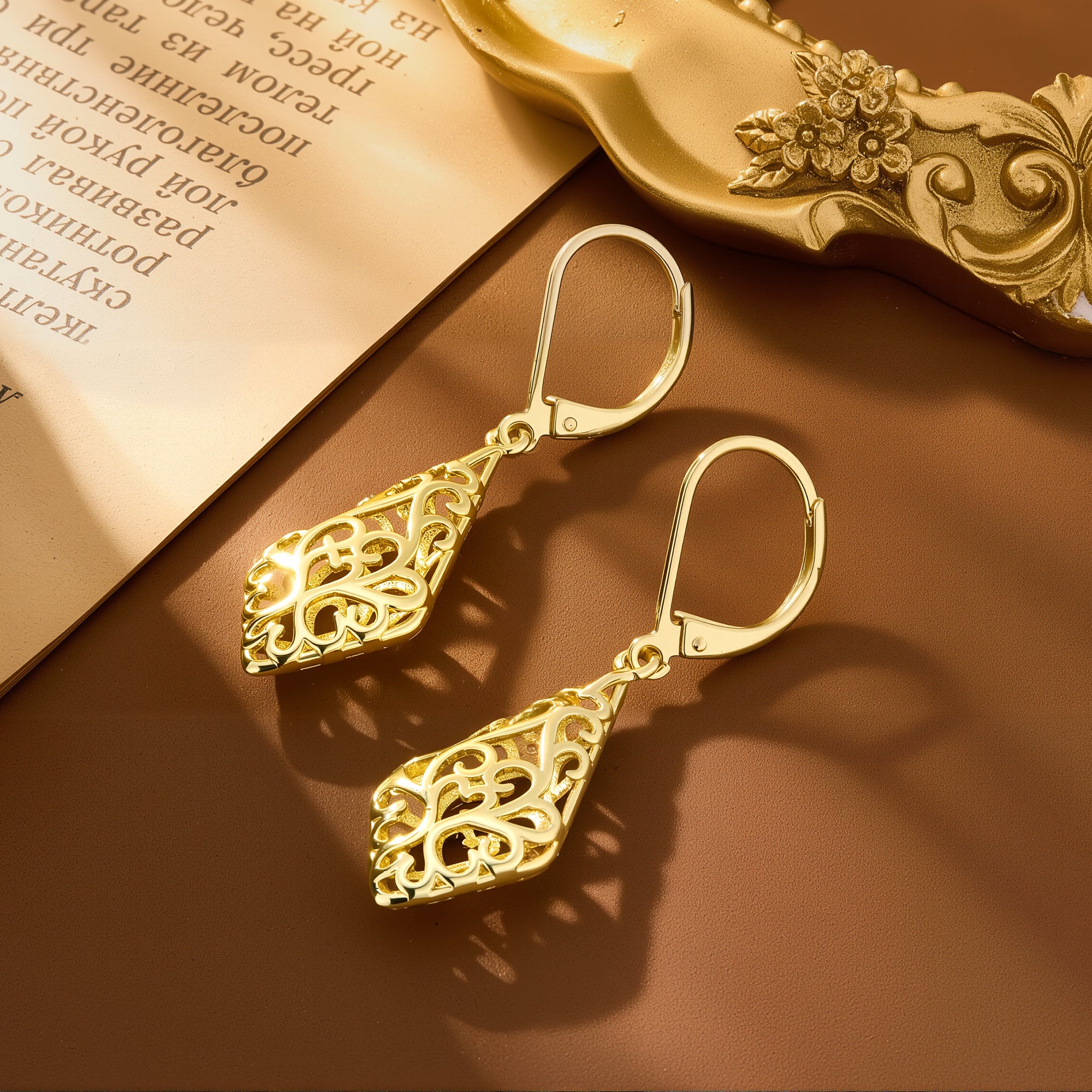 Gold-tone geometric filigree drop earrings with ornate teardrop detailing