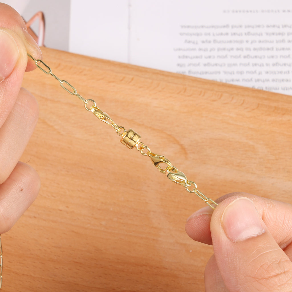 Gold magnetic necklace clasp converter close-up on chain links, held by fingers