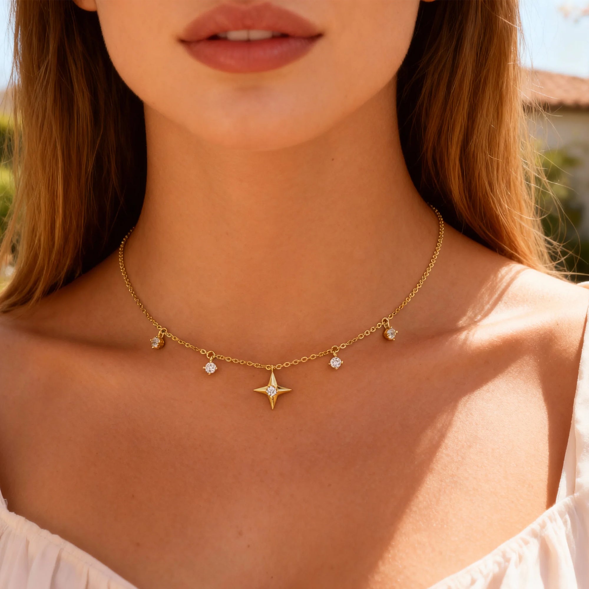 Gold-tone star pendant necklace with round zircon stations and fine chain links