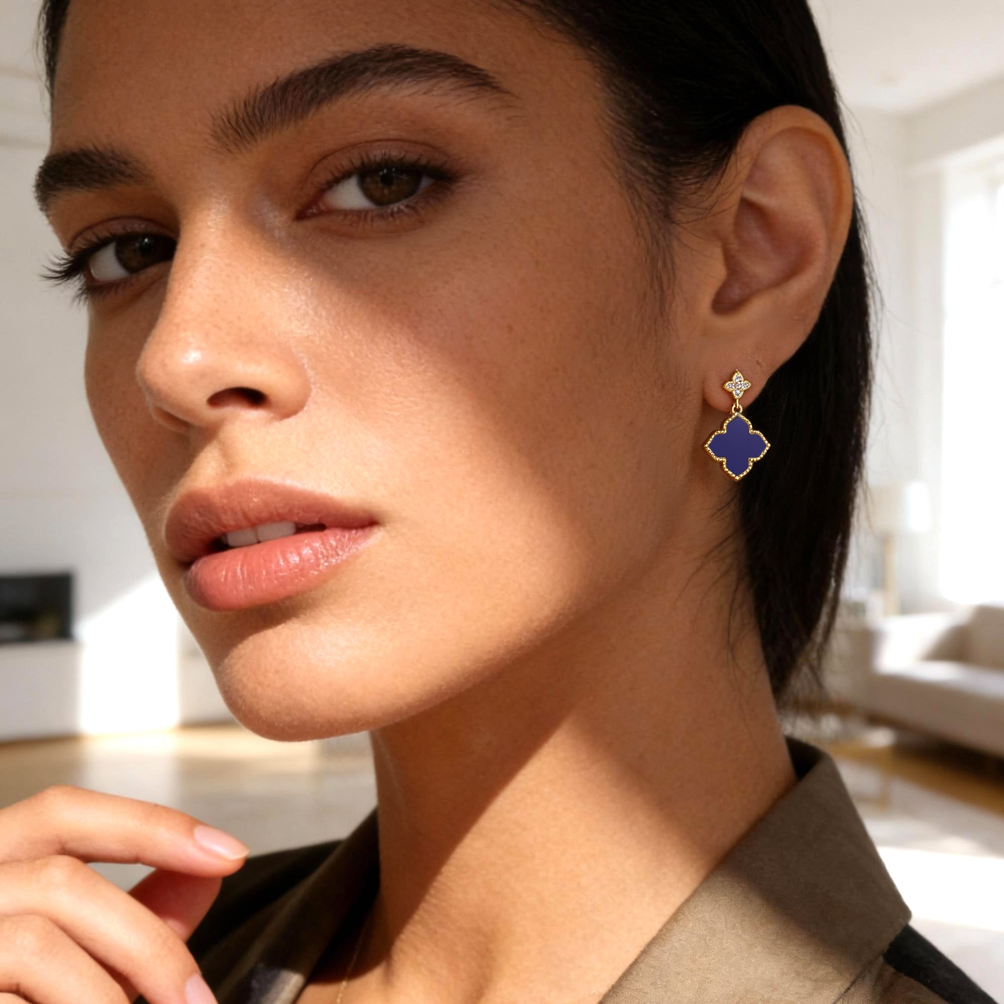 Four-Leaf Clover stud earrings on model: blue enamel clover with small clear stone accents