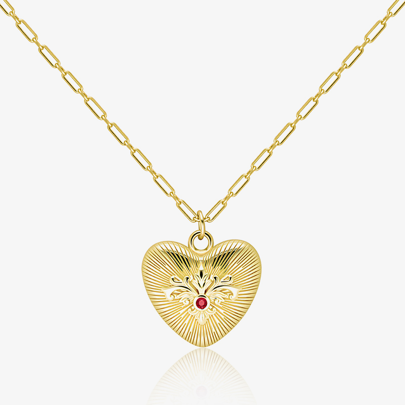 Gold paperclip chain necklace with embossed heart pendant and red gemstone center